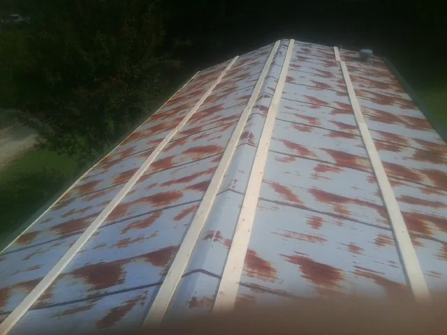 Rusted metal roof panels with new wood purlins before replacement — Storm Damage Roof Repair in Walkertown by Roofing Brothers