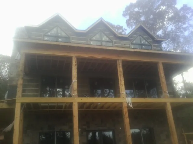 Dormers and porch framing on a large log home under construction — Roof Coating work by our crew in Walkertown