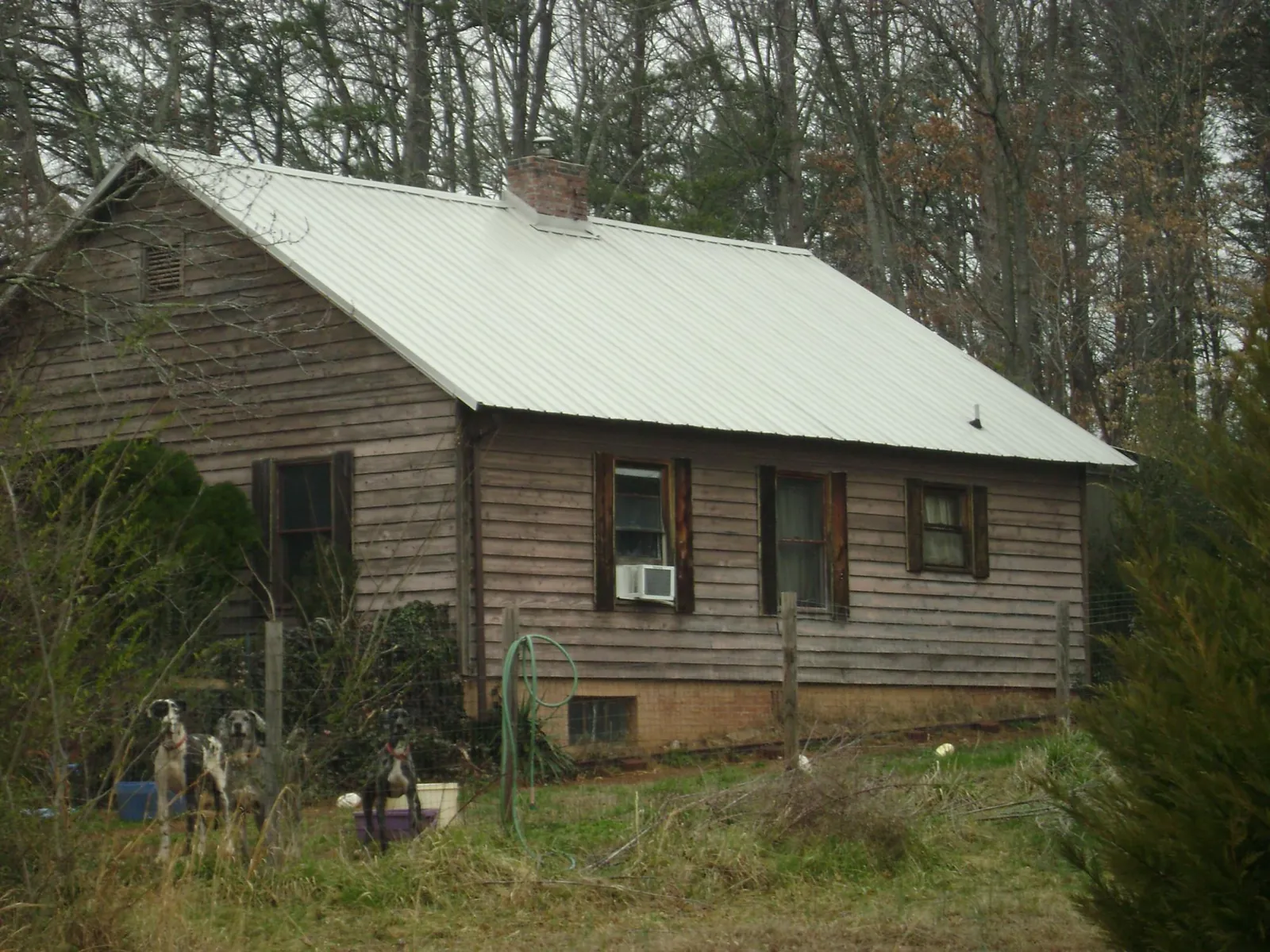 White metal roof on an old wood sided farmhouse, from a Asphalt Shingle Roof Repair job in Walkertown